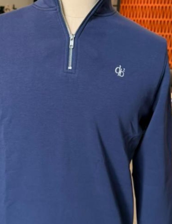 Close-up of the embroidered db² monogram and zip detail on the navy quarter zip